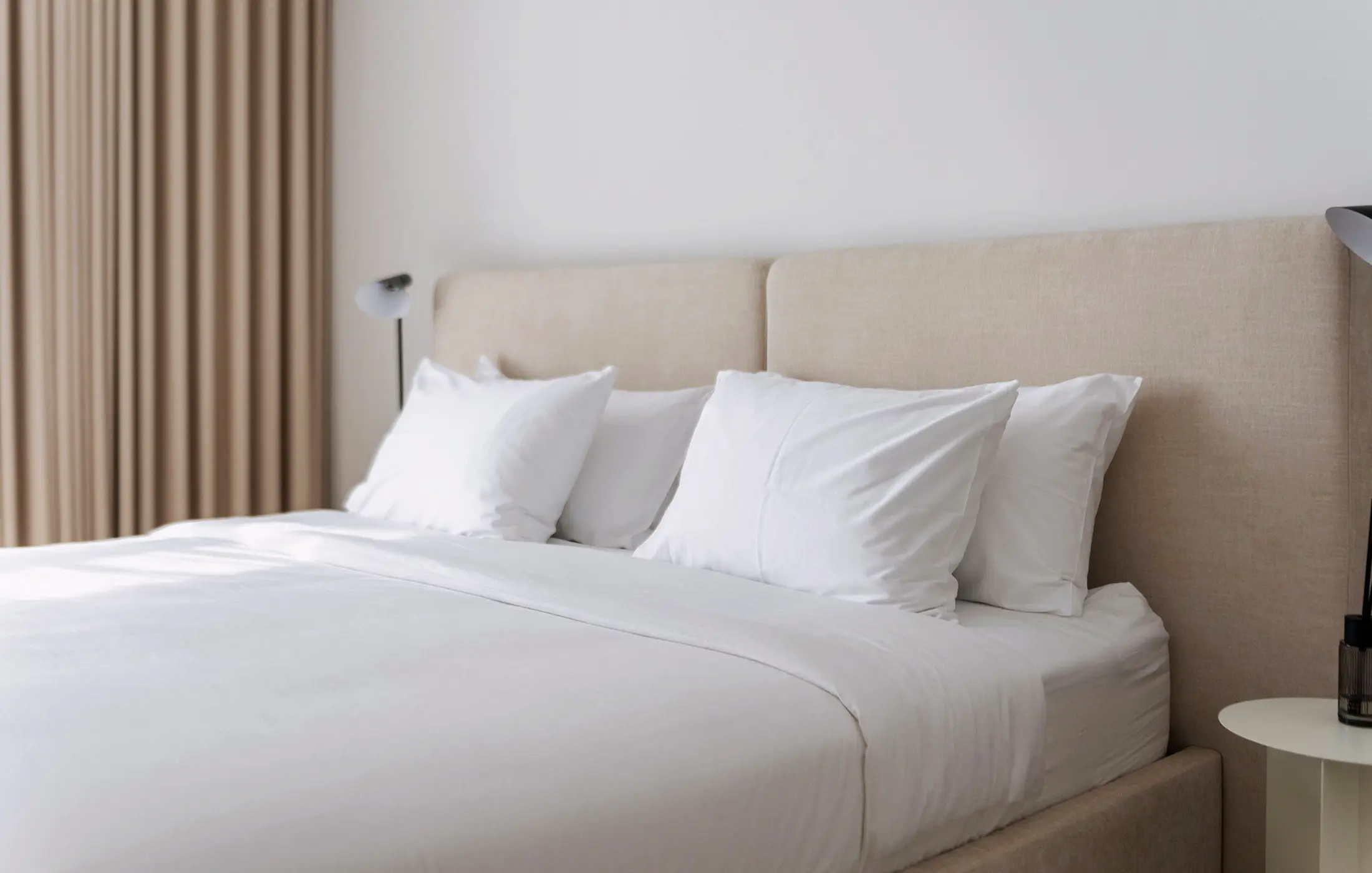 Layered white hotel pillows in soft natural light.